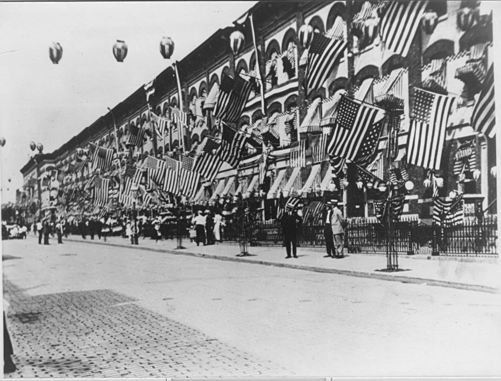 Patriotic banners flew from the Mathews Flats apartment houses on Palmetto Street between Fairview and Forest avenues in this photo taken on July 4, 1917. The revolutionary six-family dwellings were a significant addition to Ridgewood, bringing in new residents and giving building owners a second source of income.